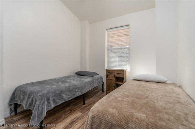 bedroom featuring dark hardwood / wood-style flooring and lofted ceiling