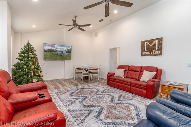 living room with ceiling fan, lofted ceiling, and hardwood / wood-style flooring