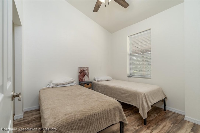 bedroom with hardwood / wood-style flooring, ceiling fan, and lofted ceiling