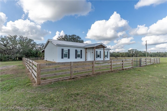 view of front of home with a front yard and a rural view