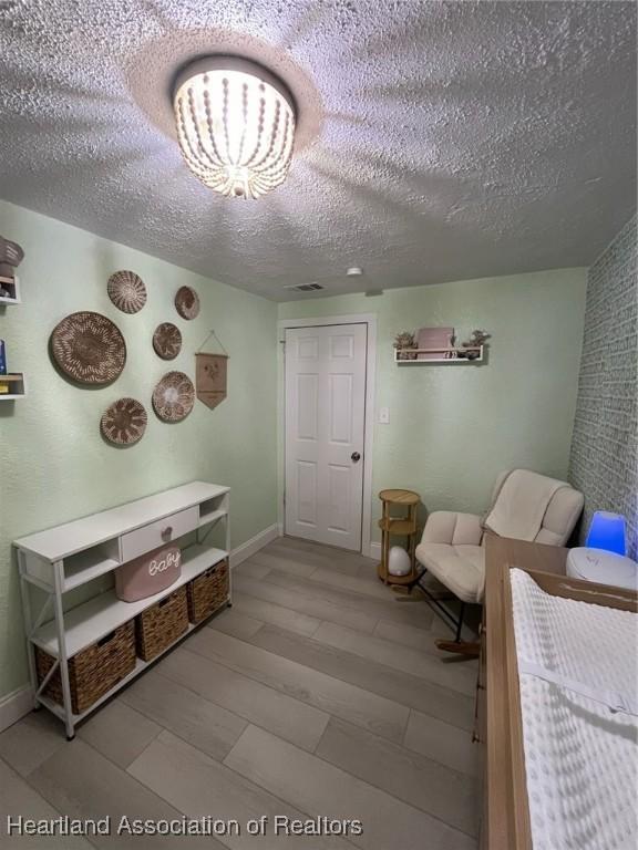 bedroom featuring a textured ceiling and light wood-type flooring