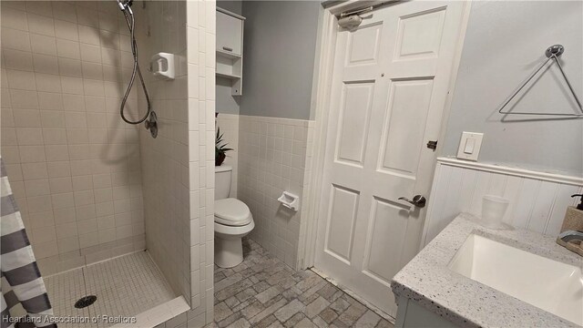 1022 Marble Ave, Avon Park, FL 33825 - full bath with tile walls, toilet, a stall shower, wainscoting, and vanity