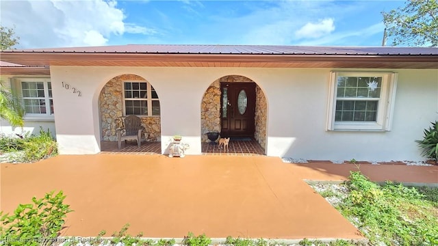 1022 Marble Ave, Avon Park, FL 33825 - entrance to property with stone siding, metal roof, and stucco siding