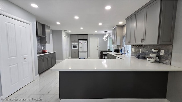 1022 Marble Ave, Avon Park, FL 33825 - kitchen with a peninsula, white refrigerator with ice dispenser, gray cabinets, and light countertops