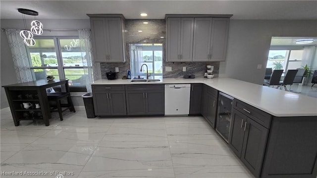 1022 Marble Ave, Avon Park, FL 33825 - kitchen with a peninsula, a sink, light countertops, marble finish floor, and dishwasher