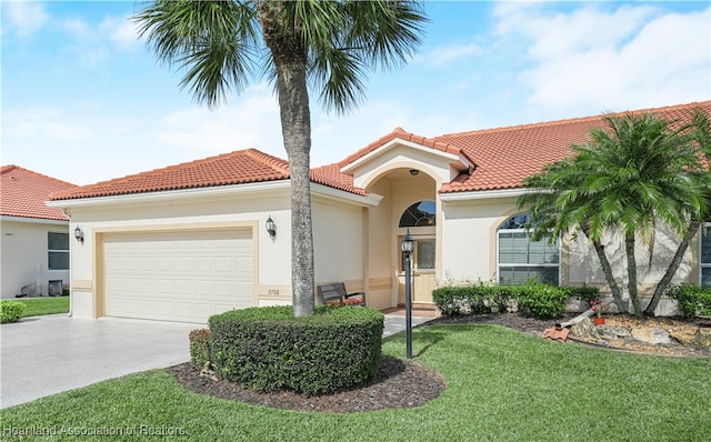 mediterranean / spanish-style home featuring a garage and a front yard