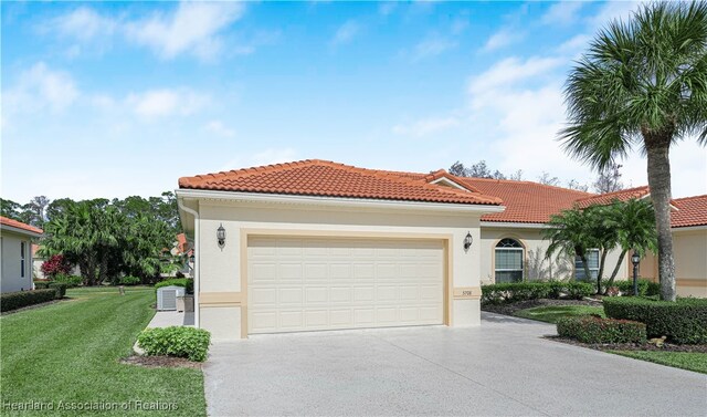 mediterranean / spanish-style home featuring a garage, a front lawn, and central air condition unit