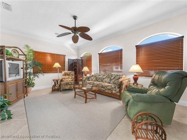 living room featuring crown molding, light tile patterned floors, and ceiling fan