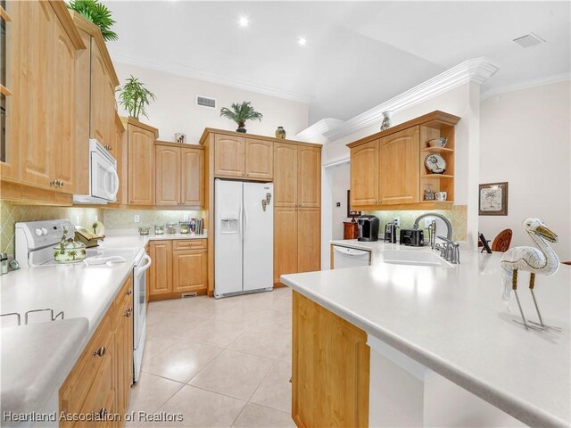 kitchen with a breakfast bar, decorative backsplash, kitchen peninsula, crown molding, and white appliances