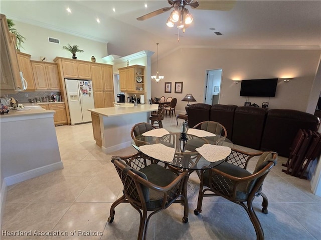 dining area with vaulted ceiling, ceiling fan with notable chandelier, sink, light tile patterned floors, and crown molding