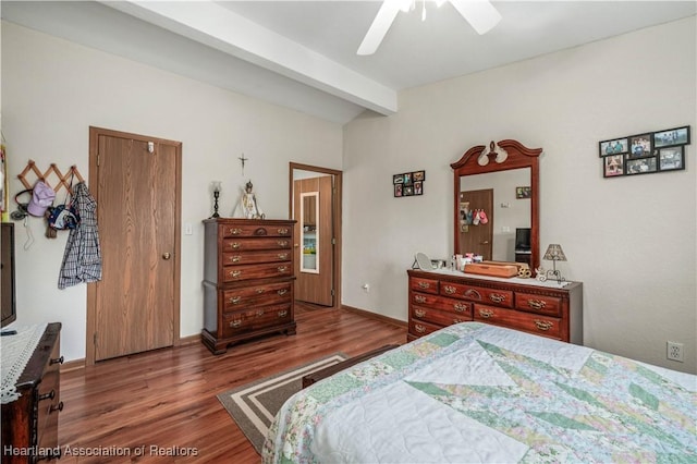 bedroom featuring beamed ceiling, dark hardwood / wood-style flooring, and ceiling fan