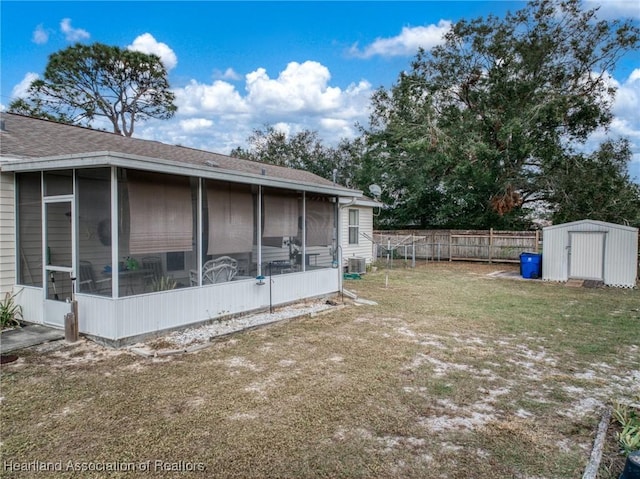 view of yard featuring a sunroom, a storage unit, and central AC unit