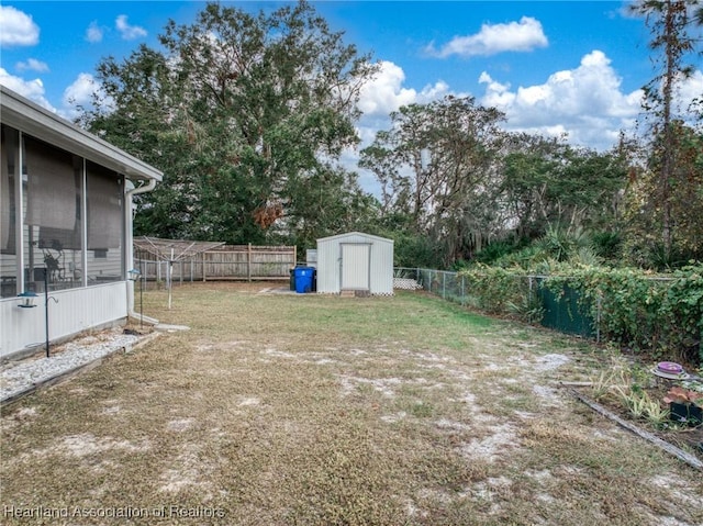 view of yard featuring a sunroom and a storage unit