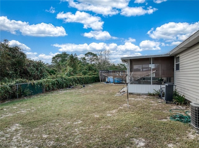 view of yard with central AC and a sunroom