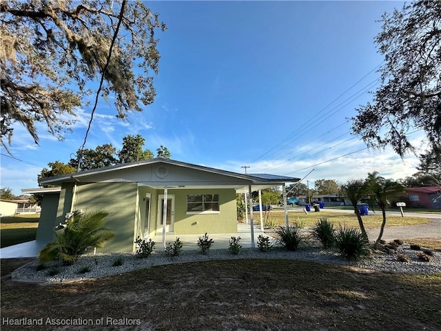 view of front of house with a front lawn and a carport