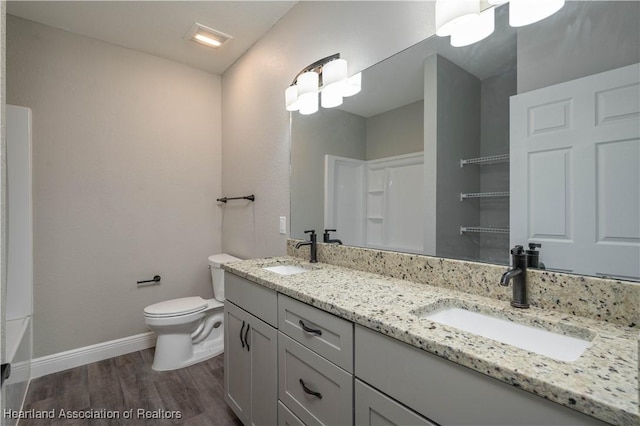 bathroom with vanity, wood-type flooring, and toilet