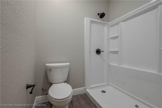 bathroom with walk in shower, toilet, and hardwood / wood-style flooring