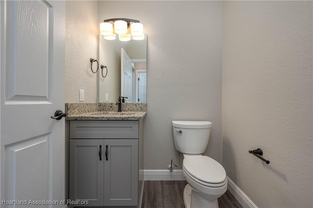 bathroom with wood-type flooring, vanity, and toilet