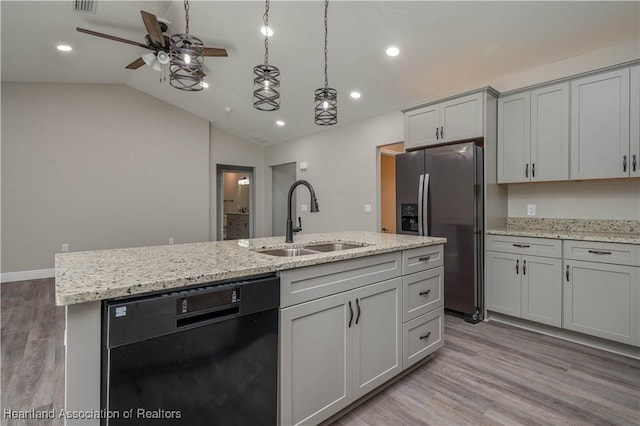 kitchen with stainless steel fridge, vaulted ceiling, a kitchen island with sink, sink, and dishwasher