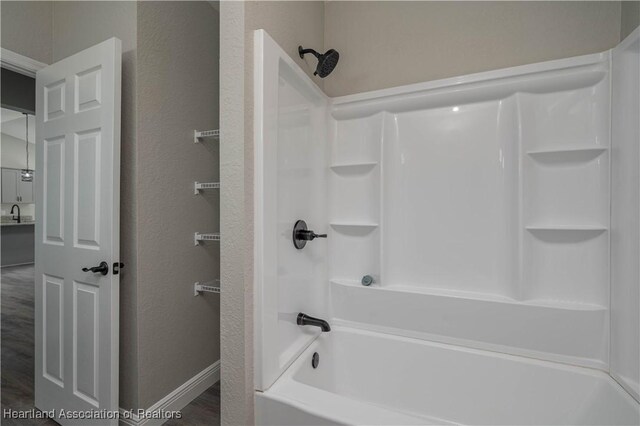 bathroom featuring hardwood / wood-style floors and shower / washtub combination