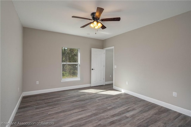 spare room with ceiling fan and dark hardwood / wood-style flooring