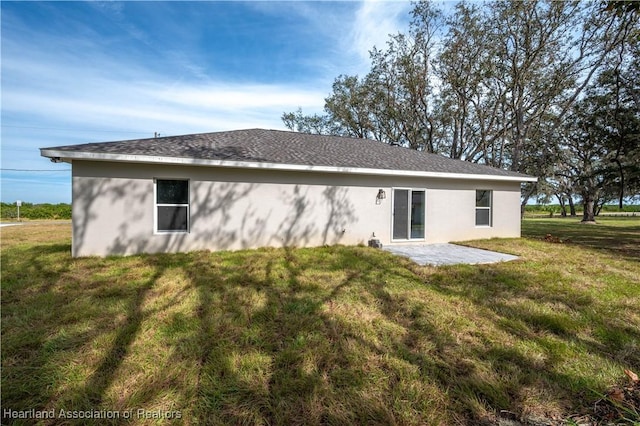 rear view of house with a lawn and a patio