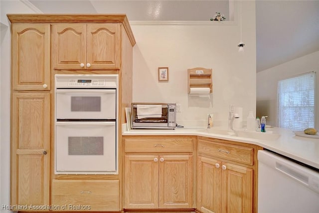 kitchen with dishwasher, light brown cabinetry, double oven, and sink