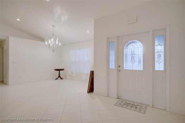 foyer entrance with a notable chandelier and lofted ceiling