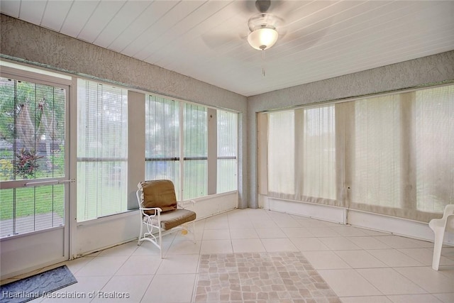 unfurnished sunroom featuring ceiling fan