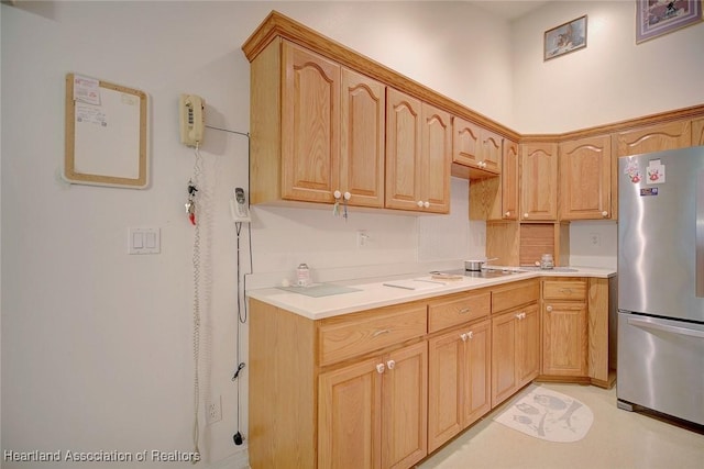 kitchen with light brown cabinets and stainless steel refrigerator