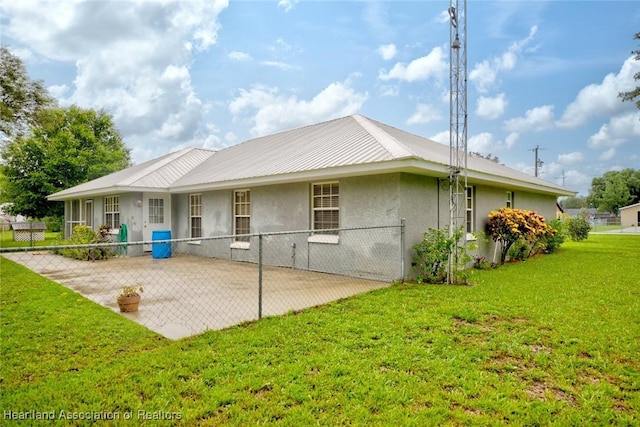 rear view of property with a yard and a patio