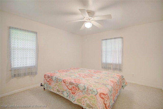 bedroom with multiple windows, light colored carpet, and ceiling fan