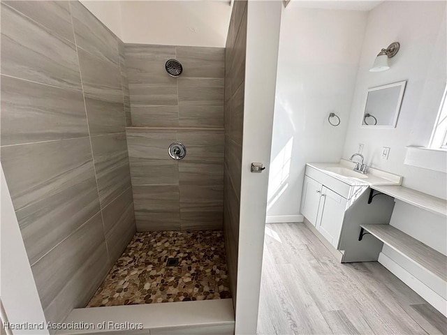 bathroom with vanity, wood-type flooring, and tiled shower