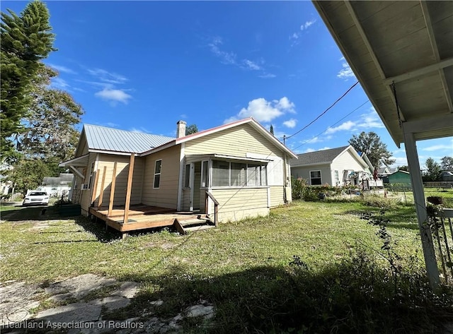 rear view of property with a yard and a wooden deck