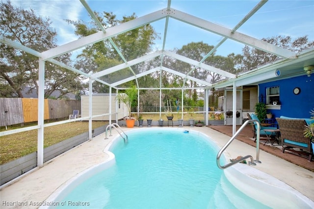 view of pool with a lanai, a storage unit, and a patio area