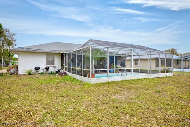 rear view of property featuring a lanai and a yard