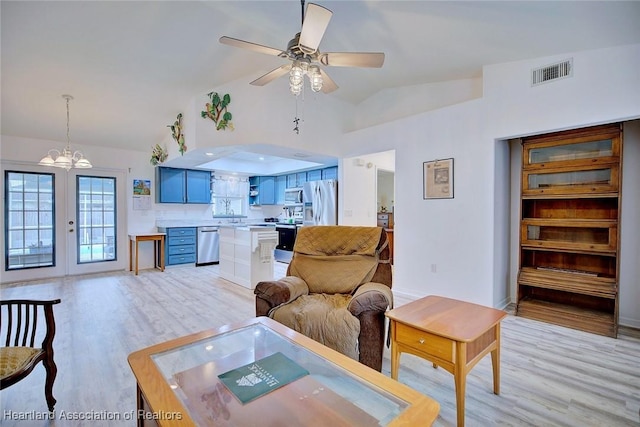 living room featuring light hardwood / wood-style floors, lofted ceiling, french doors, and ceiling fan with notable chandelier