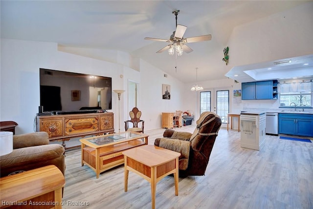 living room featuring lofted ceiling, ceiling fan with notable chandelier, light hardwood / wood-style flooring, and sink