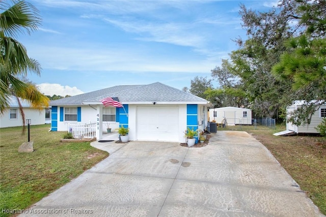 view of front of property with a front lawn, central AC, a storage shed, and a garage