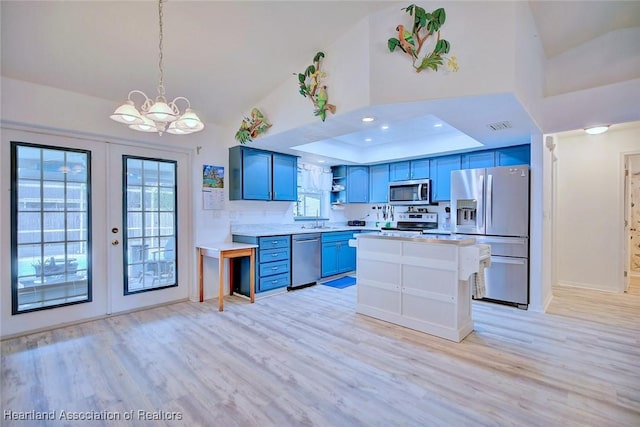 kitchen featuring vaulted ceiling, plenty of natural light, appliances with stainless steel finishes, and blue cabinets