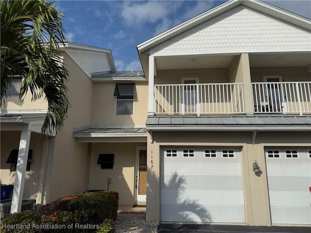 view of front of property featuring a garage and a balcony