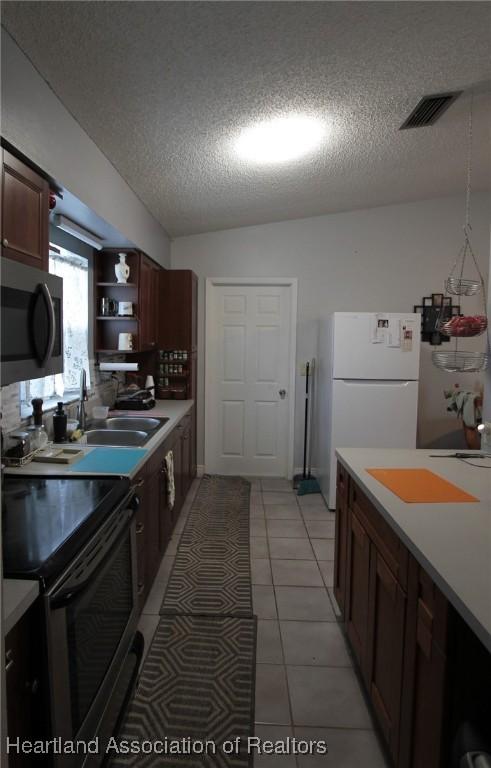 1820 W Batavia Rd, Avon Park, FL 33825 - kitchen featuring a sink, a textured ceiling, electric range, stainless steel microwave, and visible vents