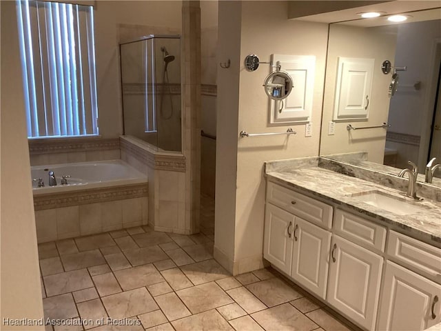 bathroom with plus walk in shower, vanity, and tile patterned floors