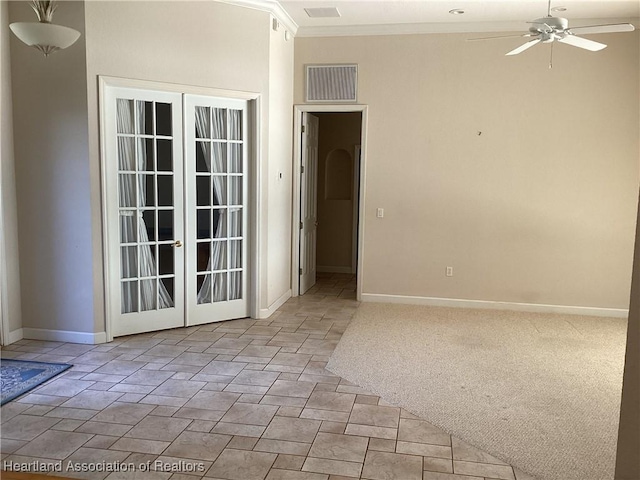 carpeted empty room featuring french doors, ceiling fan, and ornamental molding