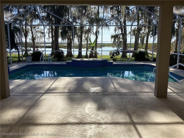 view of swimming pool with a lanai, a patio area, and a water view