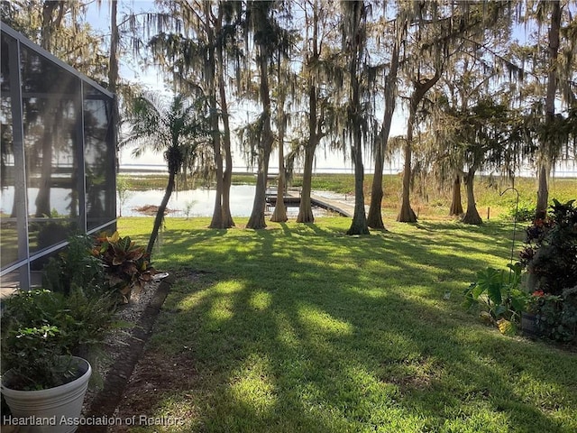 view of yard with a water view and glass enclosure