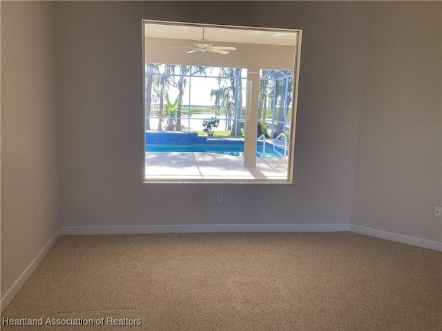 carpeted spare room with ceiling fan and plenty of natural light