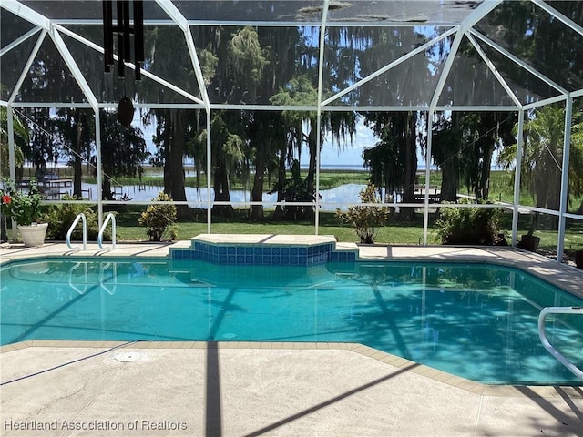 view of pool with glass enclosure and a patio area