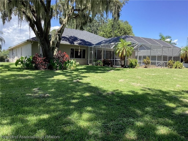 exterior space featuring a lanai and a lawn