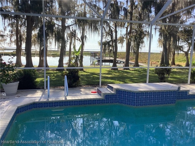 view of swimming pool with a lanai and a water view